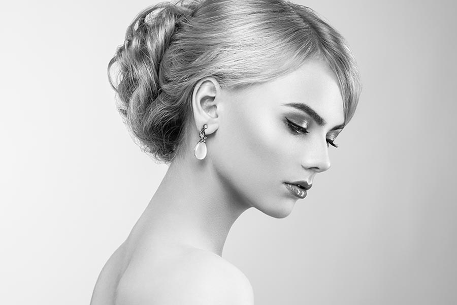 Portrait of beautiful sensual woman with elegant hairstyle. Perfect makeup. Blonde girl. Fashion photo. Jewelry and dress. Black and white