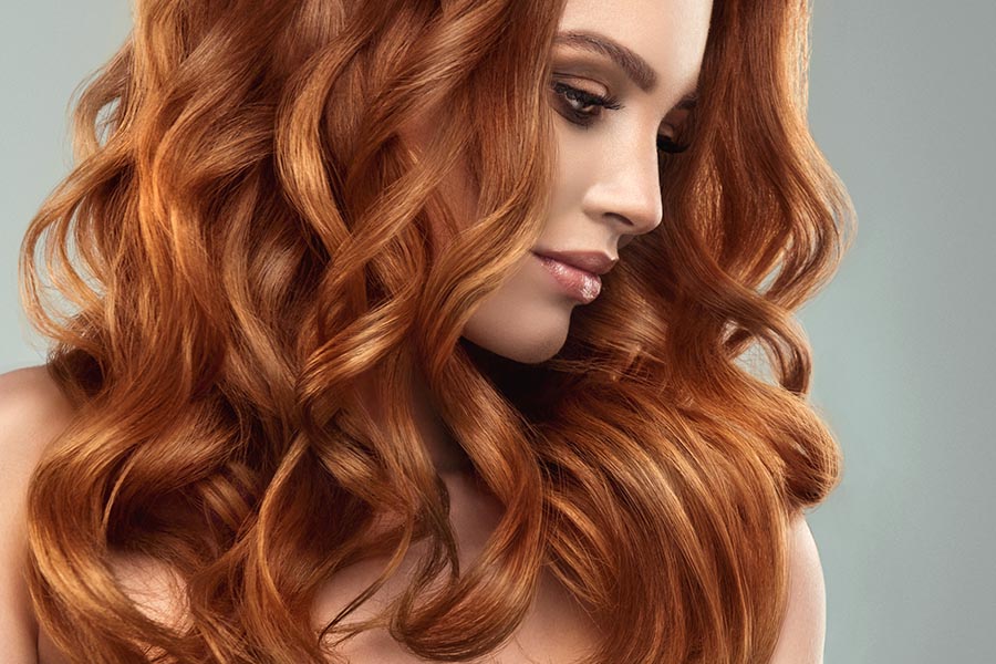 Beautiful model girl with long red curly hair Red head